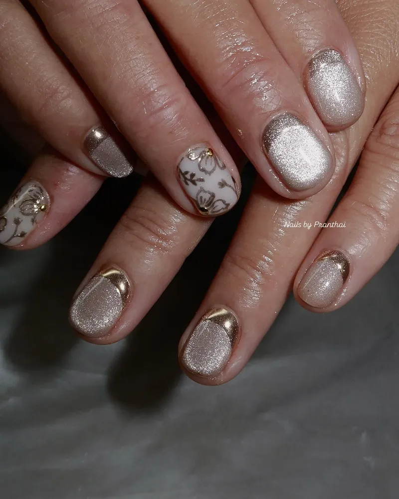 Short nails in champagne cat eye and gold chrome with small accent designs